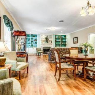 A spacious and cozy living room with a dining area, featuring hardwood floors and elegant furniture.