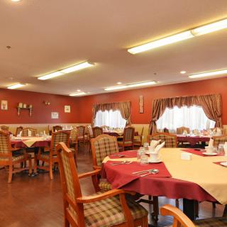 An inviting dining room with neatly set tables, soft lighting, and warm decor.