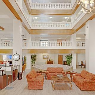 A spacious and elegant hotel lobby with a central seating area and multi-level atrium.