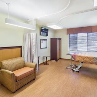A well-equipped hospital room with comfortable seating and medical facilities.