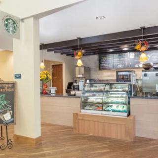 Interior of a Starbucks cafe with a display counter and menu.