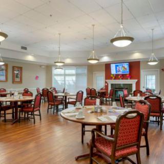 A well-lit dining area with neatly arranged tables and chairs, featuring a cozy ambiance.
