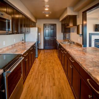 A modern kitchen interior with sleek wooden cabinets and countertops.