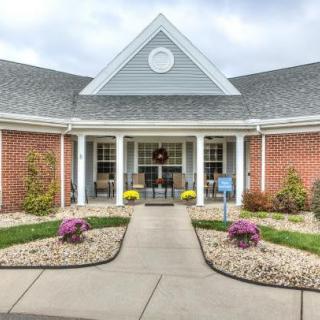 A well-maintained building entrance with neat landscaping and colorful flowers.