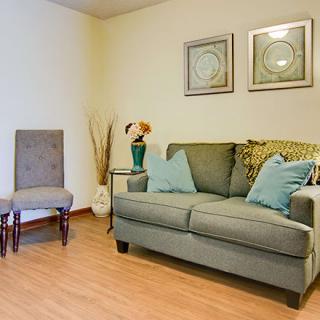 A cozy living room with a sofa, chair, and decorative elements.