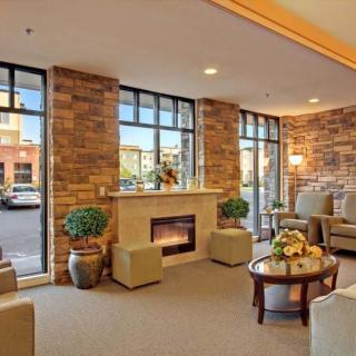 A modern lobby with comfortable seating, large windows, and a fireplace.