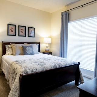 A cozy and well-decorated bedroom featuring a comfortable bed, soft lighting, and tasteful artwork.