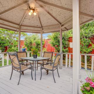 A charming gazebo with outdoor furniture set amidst a lush garden.