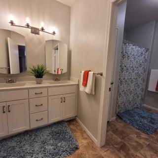 A well-lit bathroom with a vanity and shower area.