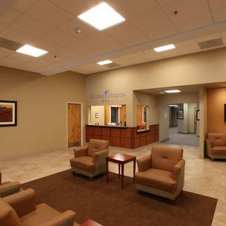 A modern waiting room with comfortable seating and a reception desk.