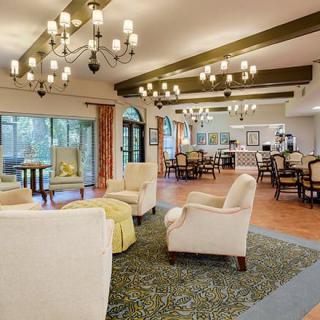 A spacious and elegantly decorated lounge area with chandeliers and comfortable seating.