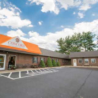 A welcoming hotel entrance with a distinctive orange roof under a partly cloudy sky.
