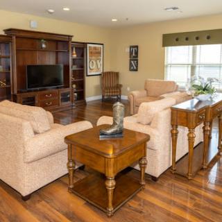 A cozy and inviting living room featuring comfortable sofas, a wooden coffee table, and a TV unit.
