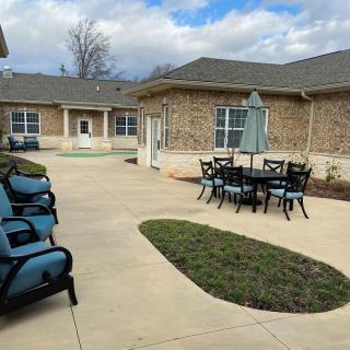 A courtyard with outdoor seating and a view of the building exterior under a cloudy sky.