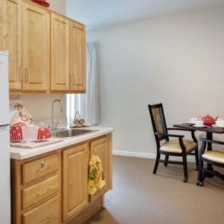 A cozy kitchen and dining area featuring wooden cabinets and a small dining table with chairs.