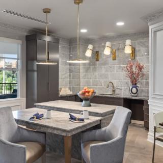 A modern kitchen interior featuring a dining area with pendant lighting and contemporary decor.
