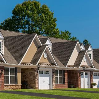 A row of suburban houses with gabled roofs and garages.