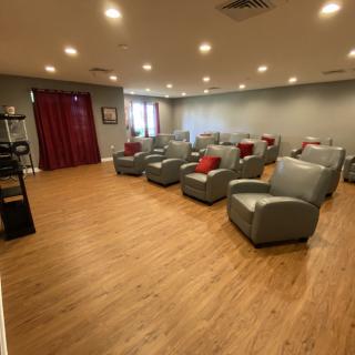 A modern lounge area with several comfortable chairs arranged in rows.