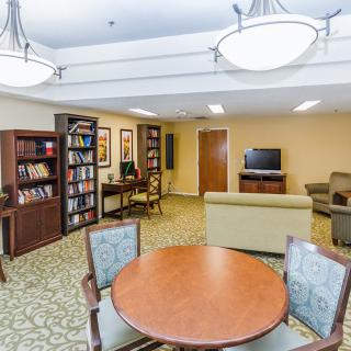 A cozy library area with bookshelves, seating, and a computer station.