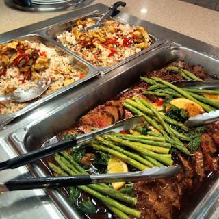 A delicious buffet selection featuring grilled meat, asparagus, and seasoned rice.