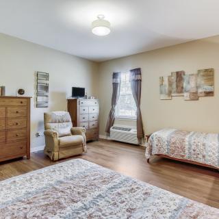 A cozy bedroom featuring a comfortable armchair, wooden furniture, and decorative elements.