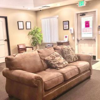 A cozy waiting room with a comfortable sofa and indoor plant.