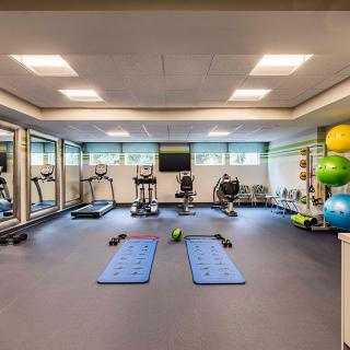 A modern, well-equipped gym with exercise machines, yoga mats, and fitness accessories.