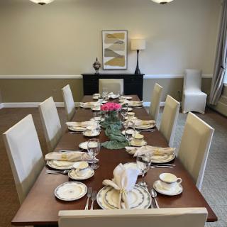 An elegantly set dining table, complete with fine china and a decorative floral centerpiece.