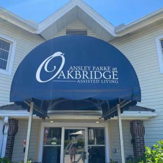 Entrance of a residential building with an awning labeled 'Oakbridge Assisted Living'.