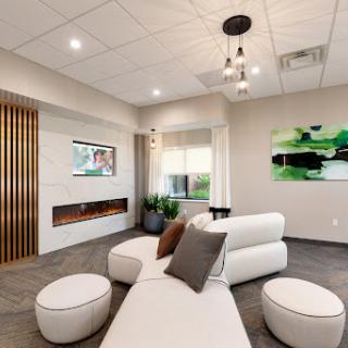 A modern lounge area featuring minimalist furniture and green accents, designed for relaxation.