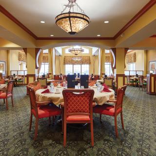 An elegant dining room with beautifully set tables and warm lighting.