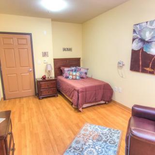 A cozy bedroom with a single bed, wooden flooring, and decorative artwork on the wall.