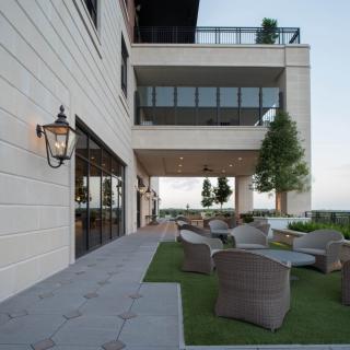 A modern building with outdoor seating on a stylish patio.
