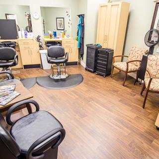 A bright and tidy hair salon with multiple styling stations and comfortable chairs.