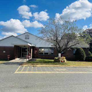 A clear day showcasing a residential or community building with a well-maintained lawn.