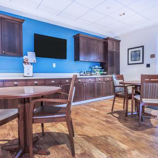 A cozy cafe area with wooden furnishings and a coffee station.