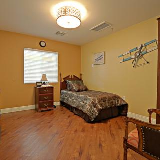 A cozy bedroom with a single bed and warm, inviting decor.