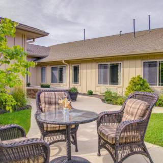 Cozy outdoor patio area with wicker furniture and a view of the garden.