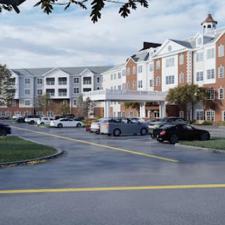 A residential building with a parking lot, set against a cloudy sky.