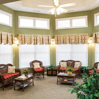 A cozy living room with ample seating and natural light from large windows.