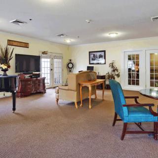 A spacious living room featuring comfortable seating, a television, and elegant decor.