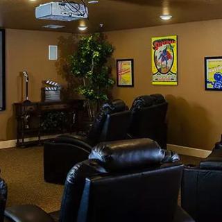A cozy home theater setup with leather seating and classic movie posters on the walls.