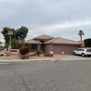 A charming single-story house with a landscaped front yard and garage, set in a quiet suburban neighborhood.