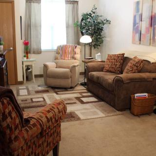 A cozy living room with a sofa, armchair, and decorative elements.