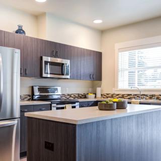 A modern kitchen with stainless steel appliances and a central island.