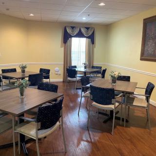 A well-arranged meeting room with tables, chairs, and decorated with flowers.