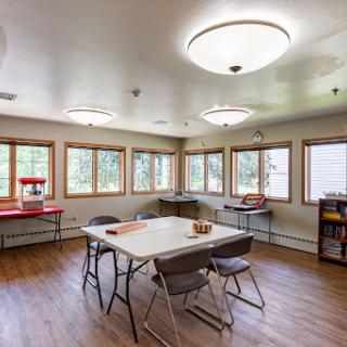 A bright and spacious meeting room with ample natural light and basic furniture.