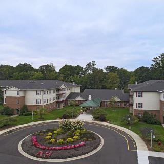 Aerial view of a residential complex with landscaped gardens and a roundabout.
