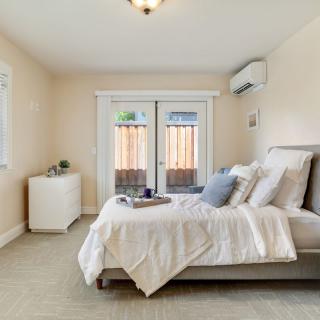 A modern and minimalist bedroom featuring a cozy bed with white linens, soft lighting, and stylish decor.