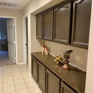 A hallway with dark wooden cabinets and decorative items on the counter.